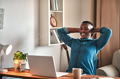 Buy stock photo Cropped shot of a handsome young businessman sitting in his home office with his hands behind his head in accomplishment