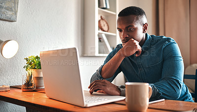 Buy stock photo Cropped shot of a handsome young businessman sitting in his home office and looking contemplative while working on his laptop