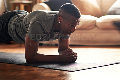 Buy stock photo Shot of a young man practising yoga at home during the day