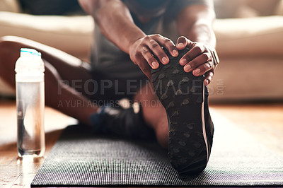 Buy stock photo Cropped shot of an unrecognizable young man stretching at home