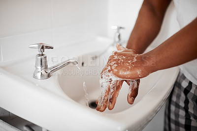 Buy stock photo Cropped shot of an unrecognizable man washing his hands in the bathroom at home