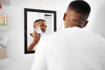 Buy stock photo Cropped shot of a young man applying shaving foam to his face