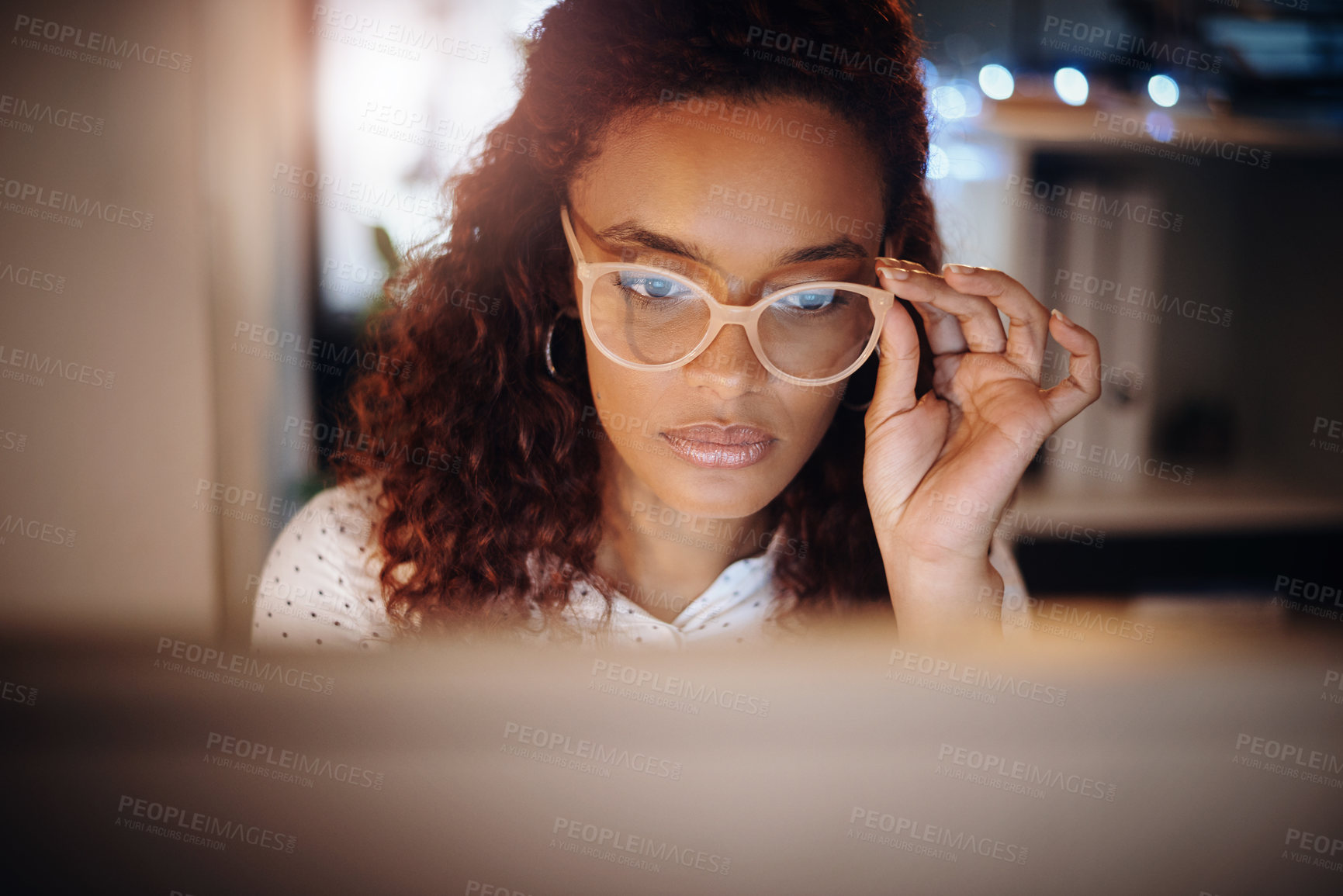 Buy stock photo Shot of a young businesswoman working on a computer in an office at night