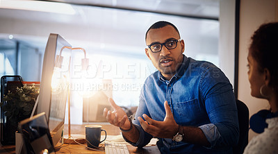 Buy stock photo Shot of two businesspeople having a discussion in an office at night