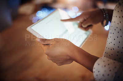 Buy stock photo Closeup shot of an unrecognisable businesswoman using a digital tablet in an office at night