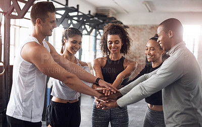 Buy stock photo Shot of a group of young people joining their hands together in solidarity at a gym