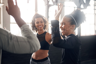 Buy stock photo Shot of a group of young people giving each other a high five during their workout in a gym