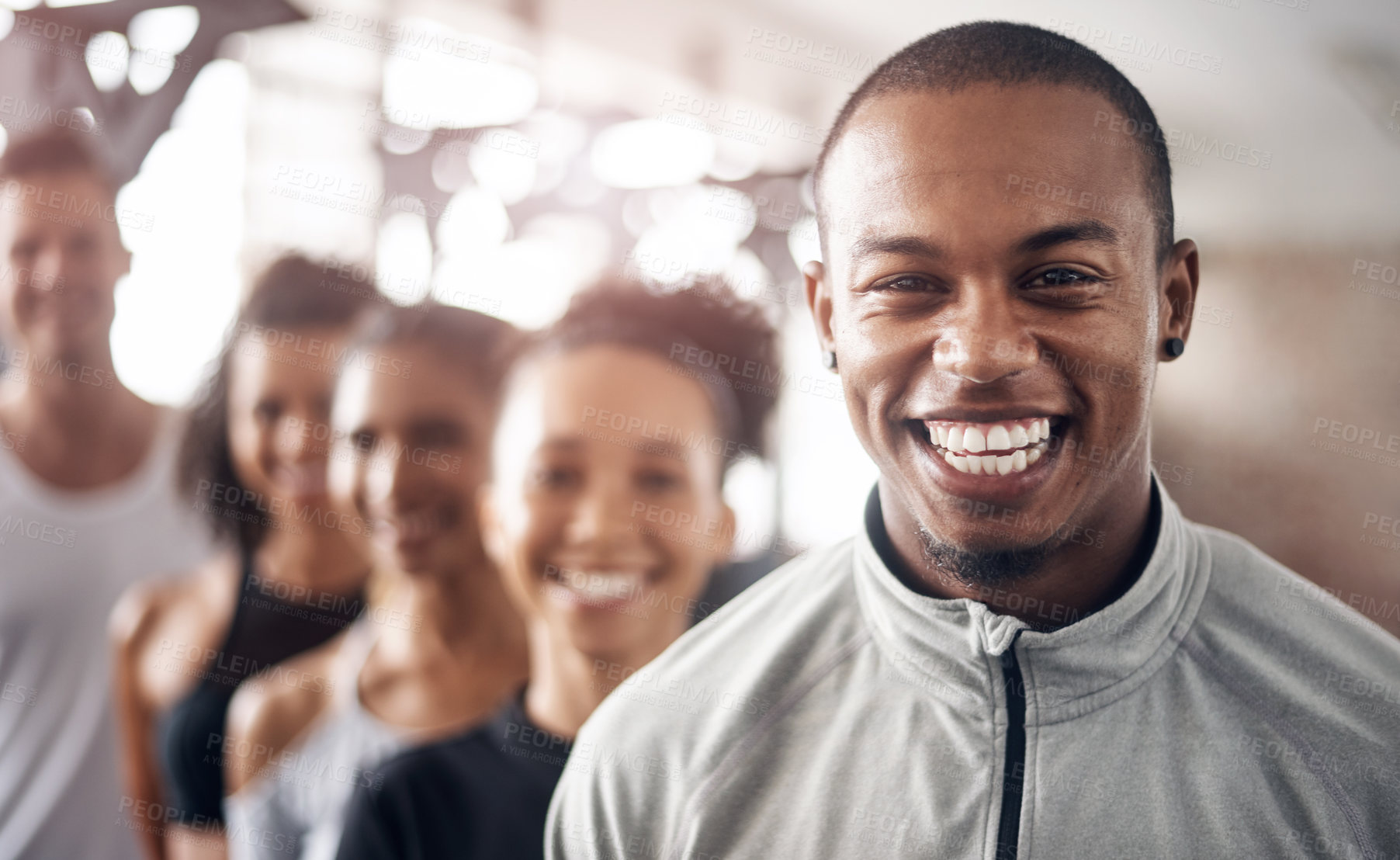 Buy stock photo Shot of a group of young people standing together in a line at the gym