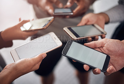 Buy stock photo Shot of a group of unrecognizable people using their mobile phones together in the gym