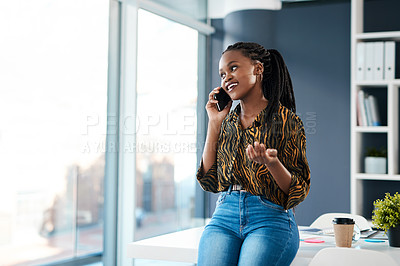 Buy stock photo Cropped shot of an attractive young businesswoman sitting in her office and talking on her cellphone
