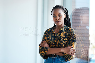 Buy stock photo Cropped portrait of an attractive young businesswoman standing with her arms folded in her office alone