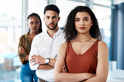 Buy stock photo Cropped portrait of an attractive young businesswoman standing with her arms crossed in front of her colleagues in the office