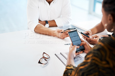 Buy stock photo Cropped shot of an unrecognizable group of businesspeople sitting in the office together and texting on their cellphones