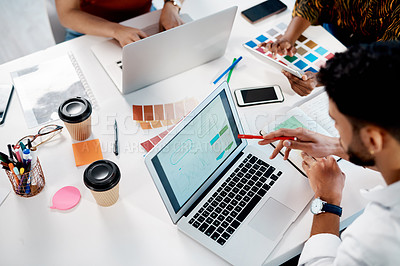 Buy stock photo High angle shot of an unrecognizable group of businesspeople sitting in the office and using colour swatches while using laptops