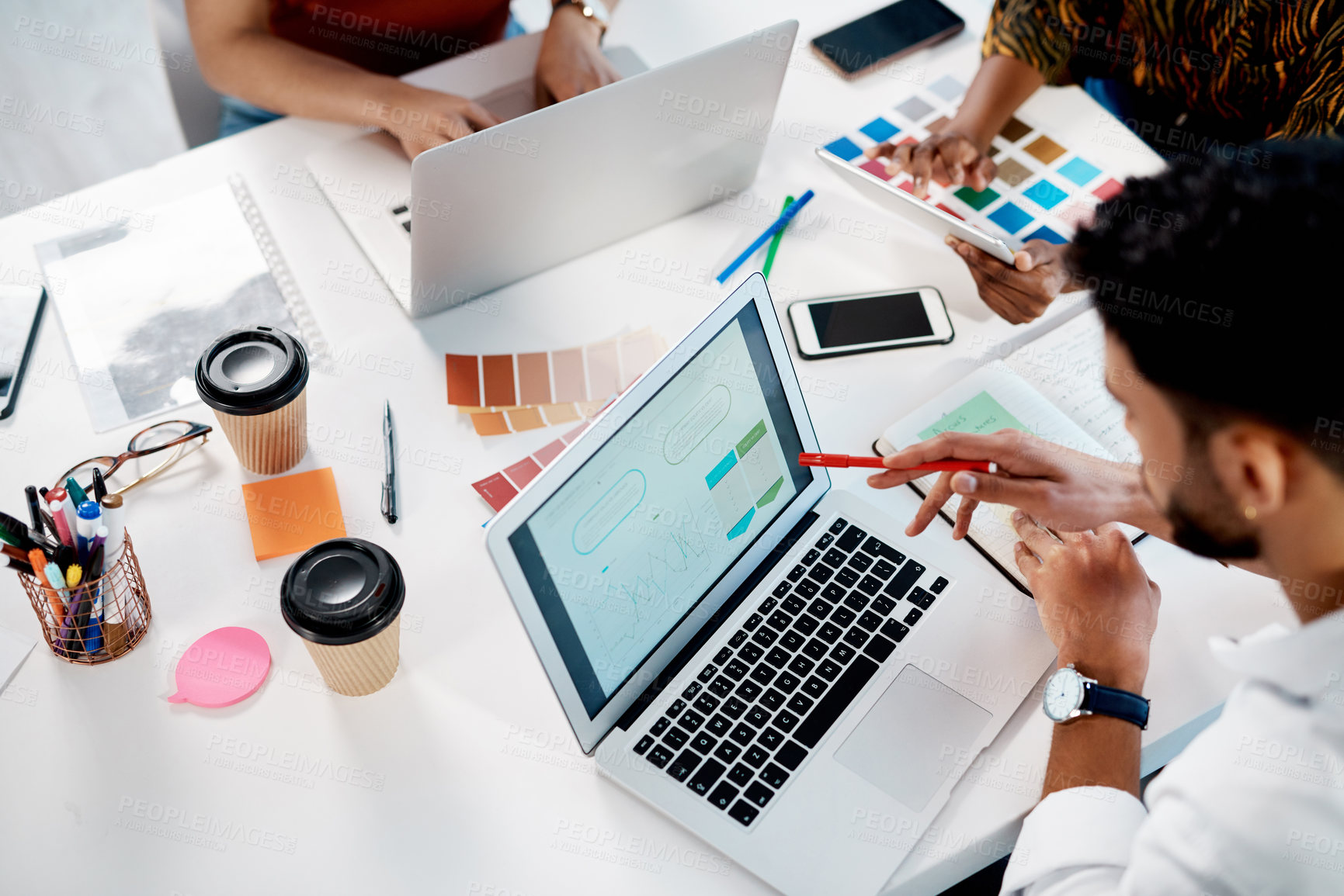 Buy stock photo High angle shot of an unrecognizable group of businesspeople sitting in the office and using colour swatches while using laptops