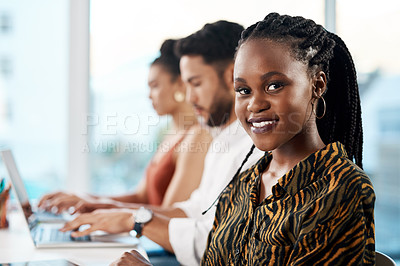 Buy stock photo Cropped portrait of an attractive young businesswoman sitting in the office while her colleagues work on laptops behind her