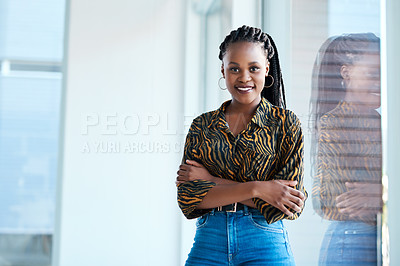 Buy stock photo Cropped portrait of an attractive young businesswoman standing with her arms folded in her office alone
