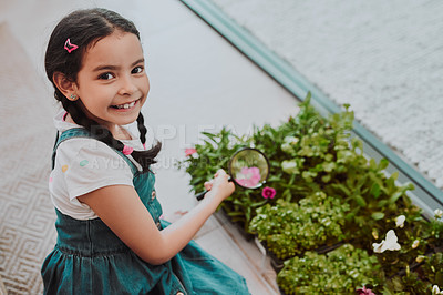 Buy stock photo Cropped portrait of an adorable little girl smiling while using a magnifying glass to analyse plants at home