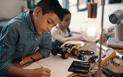 Buy stock photo Learning, writing in notebook and child with robotics homework, homeschool and science for tech project. Taking notes, car robot and boy kid with knowledge, education and studying in house alone.