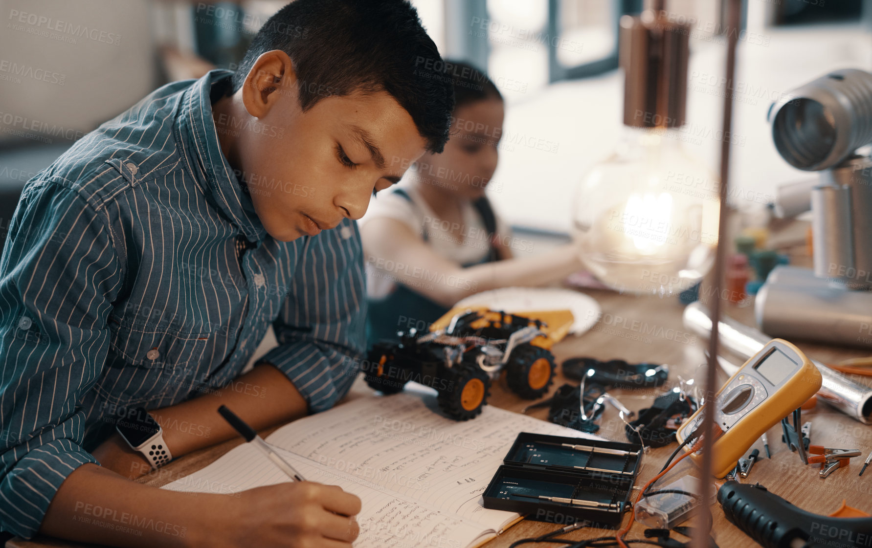 Buy stock photo Learning, writing in notebook and child with robotics homework, homeschool and science for tech project. Taking notes, car robot and boy kid with knowledge, education and studying in house alone.