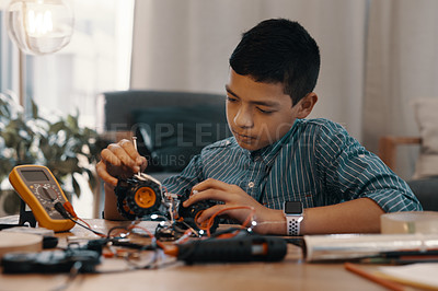 Buy stock photo Shot of a handsome young boy building a robotic toy car at home