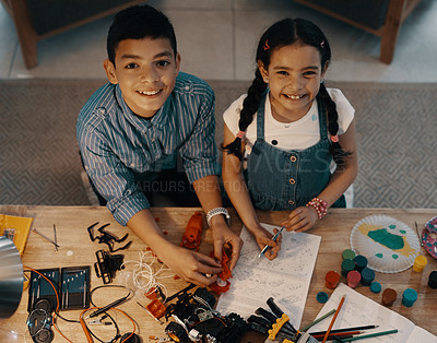 Buy stock photo High angle portrait of two adorable young siblings building a robotic toy together at home