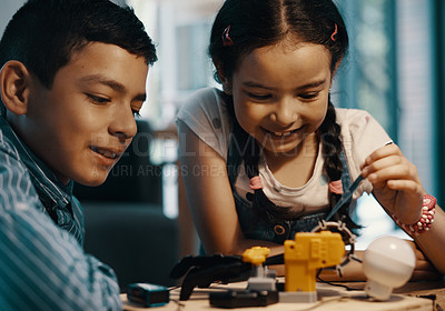 Buy stock photo Shot of two adorable young siblings building a robotic toy together at home