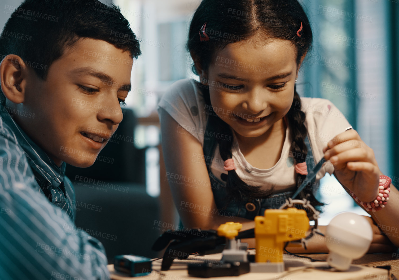 Buy stock photo Shot of two adorable young siblings building a robotic toy together at home