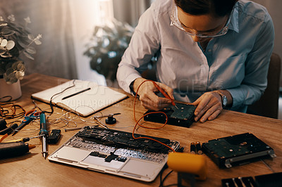 Buy stock photo Cropped shot of a young female computer technician repairing a laptop in her workshop