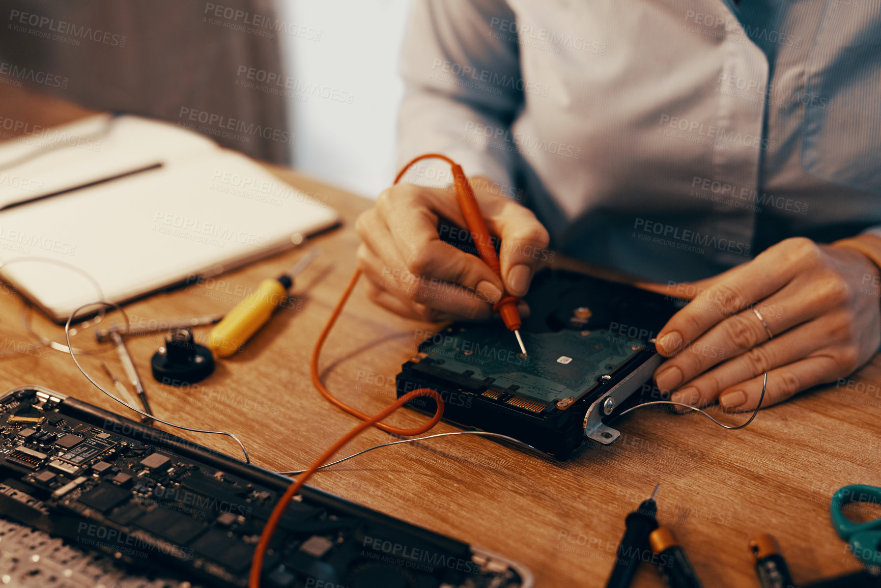 Buy stock photo Cropped shot of an unrecognizable female computer technician repairing a hard drive in her workshop