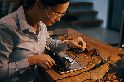 Buy stock photo Cropped shot of an attractive young female computer technician repairing a laptop in her workshop