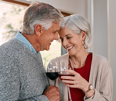 Buy stock photo Shot of a happy mature couple having red wine together during a relaxing day at home