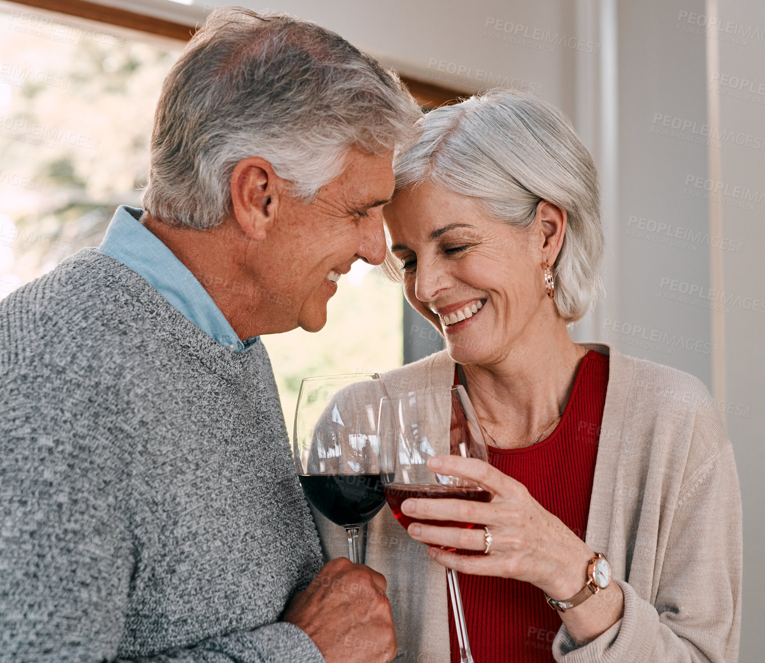 Buy stock photo Mature couple, glasses and wine to toast in home, romance and drinks for love in relationship. Happy people, forehead touch and alcohol for bonding on weekend, cheers and affection for marriage date