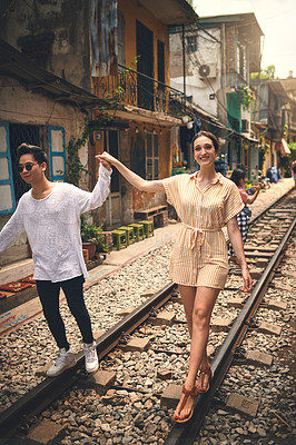 Buy stock photo Couple, love and walking by railway for travel, relationship and holiday adventure with portrait. People, trip and happy in Vietnam for vacation, romance and holding hands on date with train track