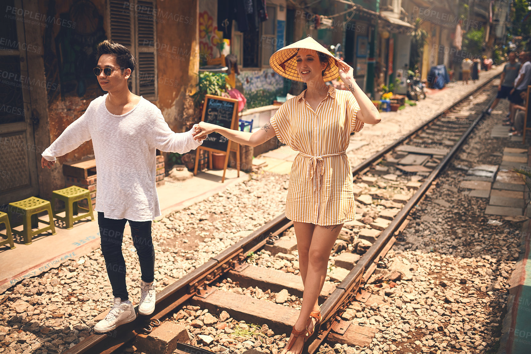 Buy stock photo Couple, love and walking by railway for vacation, relationship and holiday adventure with support. People, trip and happy in Vietnam for travel, romance and holding hands on date with train track