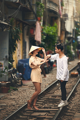 Buy stock photo Travel, holding hands and couple on train tracks for holiday, dancing and romantic outdoor date together. Love, man and woman walking in city with fun, weekend adventure and happy vacation in Vietnam