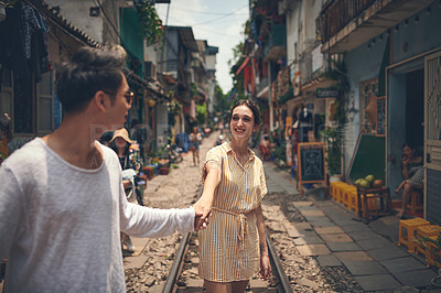 Buy stock photo Shot of a young couple walking through the streets of Vietnam
