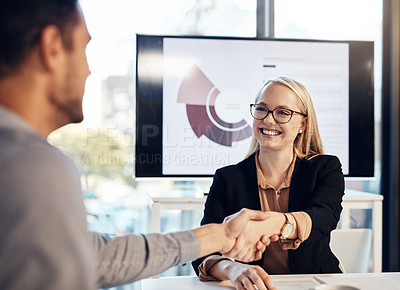 Buy stock photo Shot of a young businesswoman and businessman shaking hands during a meeting in a modern office