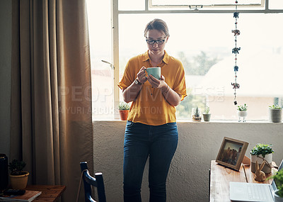 Buy stock photo Cropped shot of an attractive young businesswoman standing in her home office and holding a cup of coffee
