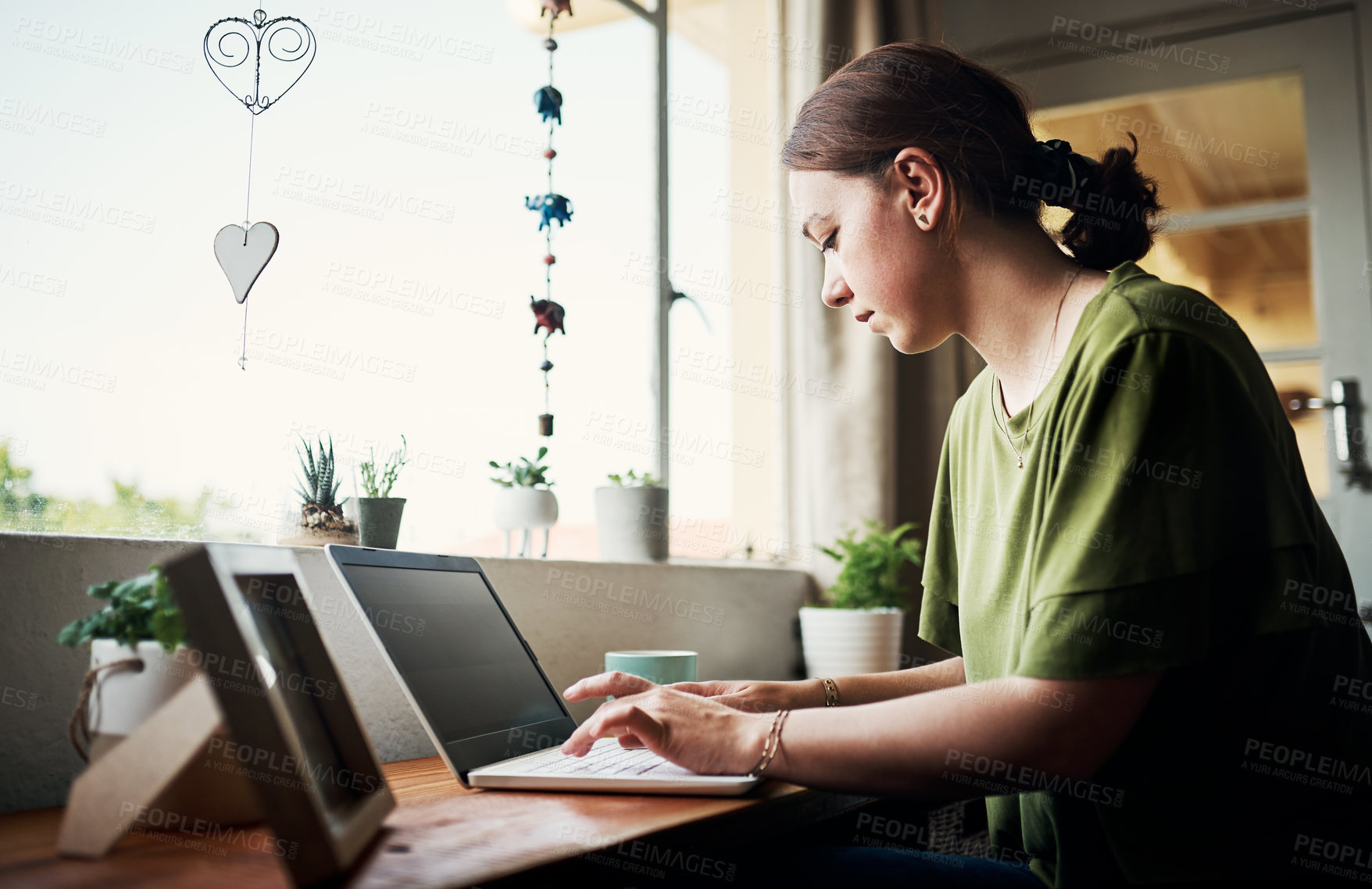 Buy stock photo Cropped shot of an attractive young businesswoman sitting alone in her home office and using her computer