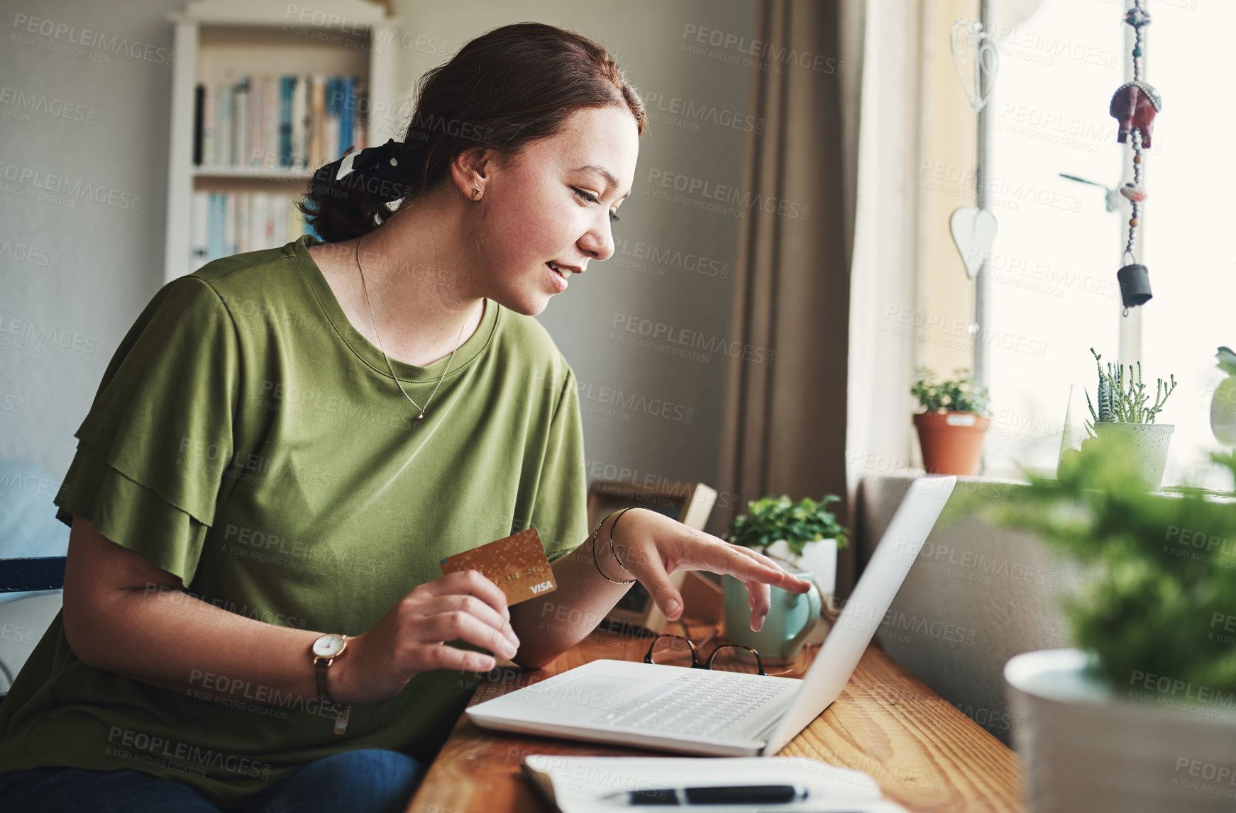 Buy stock photo Cropped shot of an attractive young businesswoman sitting alone in her home office and using her laptop for online shopping