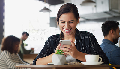 Buy stock photo Shot of an attractive young woman using a cellphone in a cafe