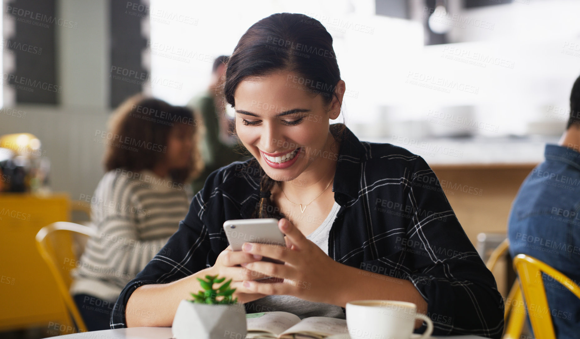 Buy stock photo Shot of an attractive young woman using a cellphone in a cafe