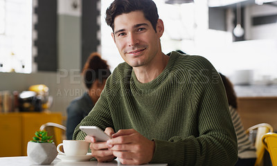 Buy stock photo Portrait of a handsome young man using a cellphone in a cafe