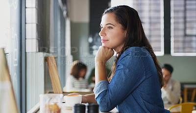 Buy stock photo Shot of an attractive young woman looking thoughtful in a cafe