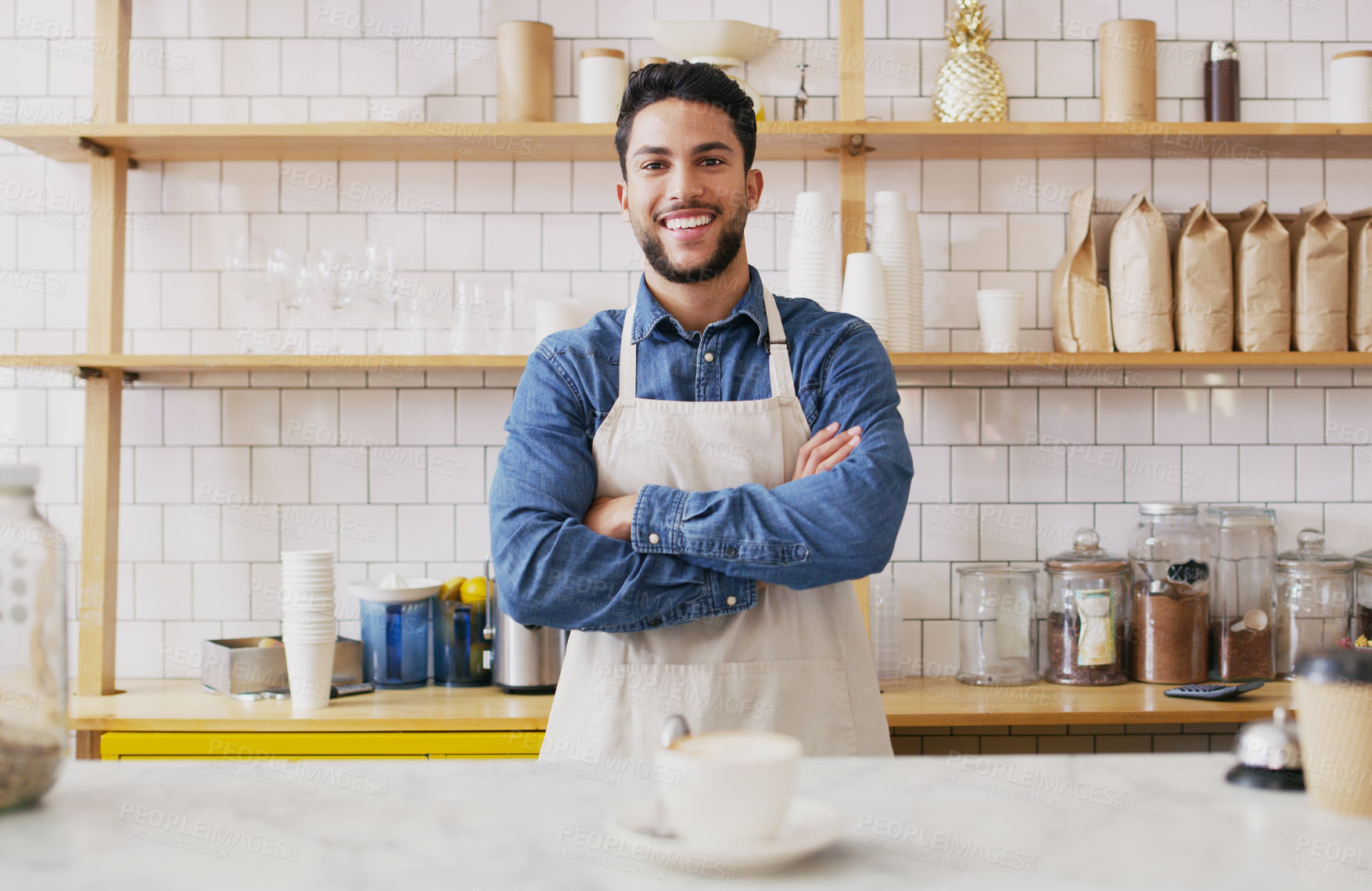 Buy stock photo Portrait of a young waiter standing behind a counter in a cafe