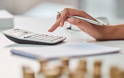 Buy stock photo Cropped shot of an unrecognizable businesswoman working out her finances with a calculator and a notepad in her office