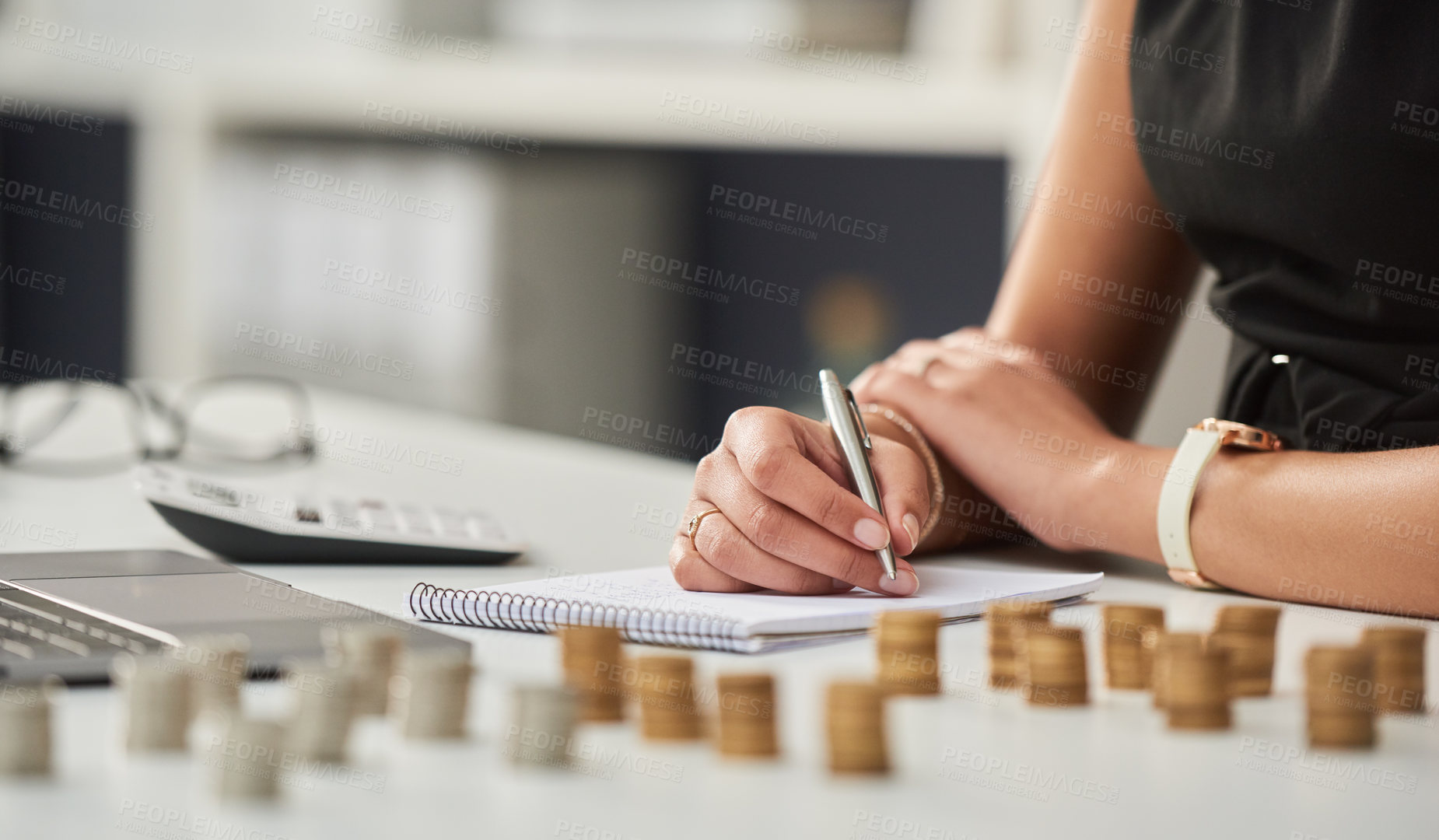 Buy stock photo Cropped shot of an unrecognizable businesswoman working out her finances with a calculator and a notepad in her office