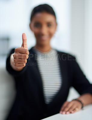 Buy stock photo Defocused shot of a young businesswoman posing with her thumbs up at work