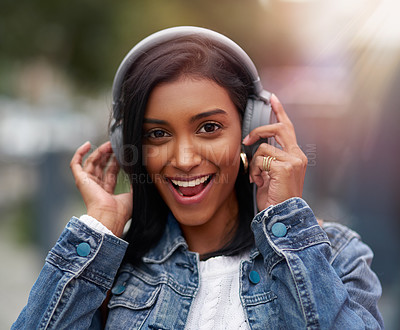 Buy stock photo Headphones, portrait or happy Indian woman in city or town for streaming a song, music or radio. Smile, student or girl listening to audio on online subscription in urban are for wellness or break